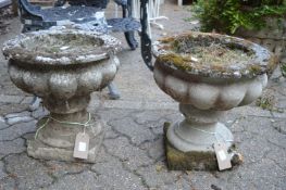 A pair of reconstituted stone pedestal planters.