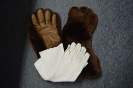 A pair of bear skin gloves and a pair of ladies gloves.