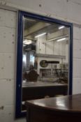 A rectangular wall mirror with blue painted frame.