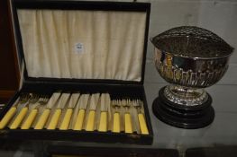A cased set of six fish knives and forks and a plated rose bowl with stand.