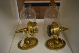 A pair of brass wall lights with etched glass shades.