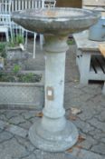 A large reconstituted stone bird bath.