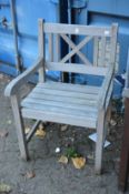 A pair of hardwood garden armchairs.