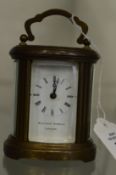 A small brass oval cased carriage clock retailed by Matthew Norman, London.