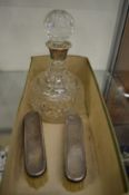 Silver mounted cut glass decanter and two silver backed brushes.