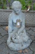 Reconstituted stone garden ornament modelled as a seated female nude.