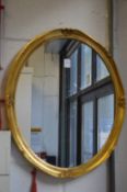 A small gilt framed oval wall mirror.