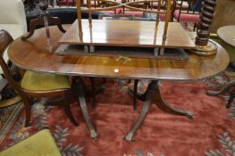 A reproduction mahogany twin pillar dining table with two leaves.