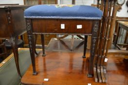 A mahogany and upholstered music seat.