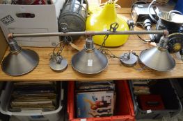 A three light pendant light fitting.