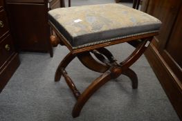 A mahogany adjustable music seat with X shaped support.