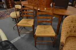 A pair of rush seated ladder back dining chairs, possibly American.