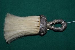 A silver handled brush.