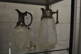 Two engraved glass claret jugs with plated mounts (one cover detached).