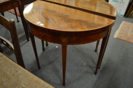 An Edwardian mahogany D shaped fold-over card table with inlaid decoration.
