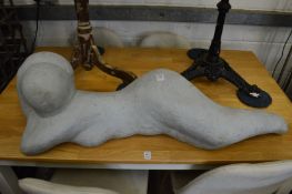 A resin sculpture of a reclining female nude.