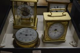 A brass carriage clock and three other clocks.