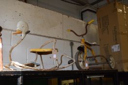 A childs rocking toy and a tricycle.