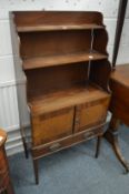 A small bookcase with two cupboard doors and a single long drawer.