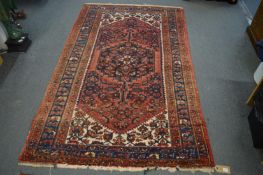 A Persian rug, red ground with stylised decoration, 204cm x 128cm.