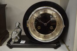 An Art Deco mantel clock mounted with a chrome plated seated female figure.