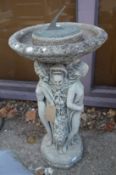 A reconstituted stone combination sundial and bird bath with figural base.
