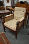 A good 19th century Regency mahogany bergere armchair with carved rams head arm terminals, upholste