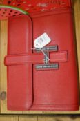 A ladies red leather clutch bag.