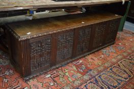 A large oak coffer with carved panelled front.