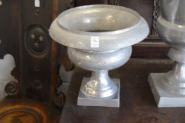 A pair of aluminium pedestal urns.