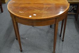 An Edwardian inlaid mahogany D shaped fold-over card table.