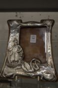 A good embossed silver photograph frame depicting a Viking and swans.