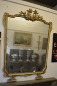 A large decorative parcel gilded and painted overmantel mirror.