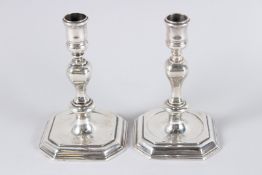 A GOOD MATCHED PAIR OF GEORGE II CAST SILVER CANDLESTICKS with matching period crest. 5.5ins high.