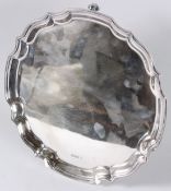 AN ELKINGTON & CO SILVER PIE RUST SALVER on claw and ball feet. 9.5ins diameter. London. Weight