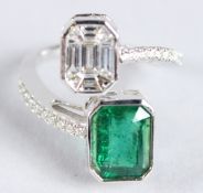 A VERY GOOD 18CT WHITE GOLD EMERALD AND DIAMOND CROSSOVER RING.