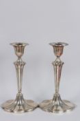 A PAIR OF VICTORIAN SILVER CANDLESTICKS on oval shaped loaded bases. 9ins high. Birmingham 1893.