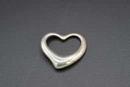 A TIFFANY & CO SILVER HEART in a Tiffany & Co bag.