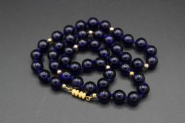 A LAPIS BEAD NECKLACE. 20ins long.