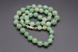 A GREEN JADE BEAD NECKLACE. 18ins long.