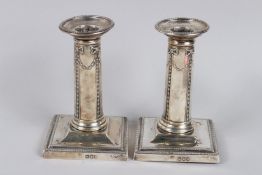 A PAIR OF VICTORIAN SILVER CANDLESTICKS on square bases. 4.5ins high.