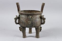 A CHINESE ARCHAIC TWO HANDLED CIRCULAR CENSER on three curving feet 24cm high