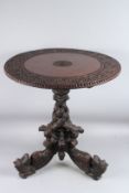 A GOOD BURMESE CARVED TILT TOP TABLE with circular top on an entwined base, with dragon feet 70cm