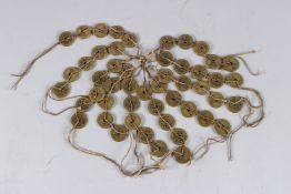 A STRING OF CHINESE METAL COINS