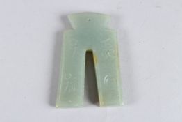 A CHINESE JADE PENDANT shaped like an ancient coin