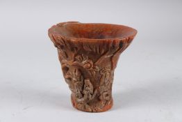 A GOOD CARVED HORN LIBATION CUP the sides carved with figures and folliage 12cm high
