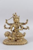 A CHINESE GILT BRONZE MULTI-ARM DEITY SITTING ON A DRAGON, set with stones. 22cms high.