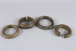 FOUR AFRICAN BRASS BRACELETS