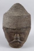 A SOUTH EAST ASIA CARVED STONE HEAD the hat lifts off to reveal a storage jar 26cm high