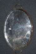 A George III oval silver twin handled tray with bead work border, engraved armorial to the centre.